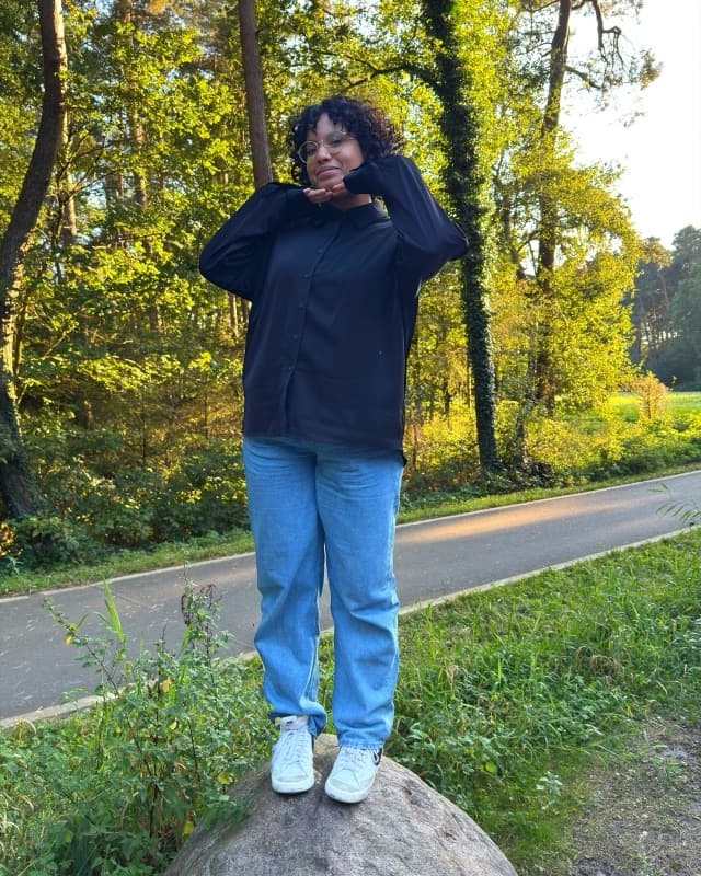 Me standing on a rock by a tree-lined path in the evening sun